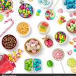 Candies, chocolates and lollipops on a white background background. Backdrop, banner o background with sweets. Top view of colorful sweets.